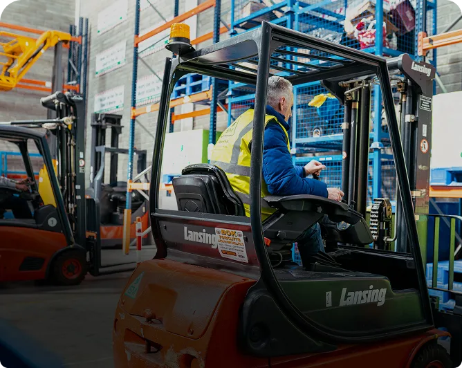 A_man_in_a_safety_vest_drives_a_forklift_ISM_Driving_lessons