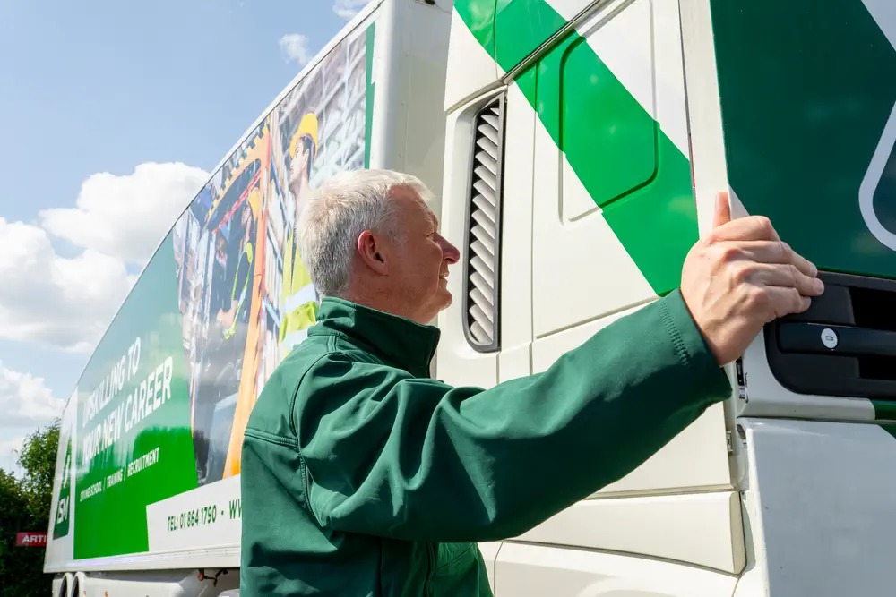 A_man_in_a_green_jacket_points_towards_a_truck _ISM Training_and_Recruitment