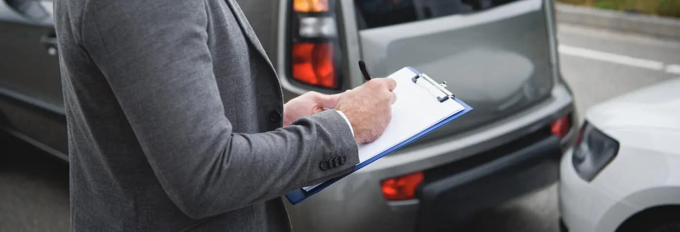 A_man_in_a_suit_stands_beside_a_car _ISM Training_and_Recruitment