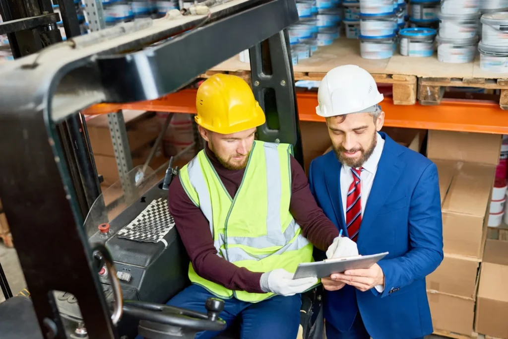 Two_men_in_hard_hats_and_safety_vests_examining_a_tablet_together _ISM Training_and_Recruitment