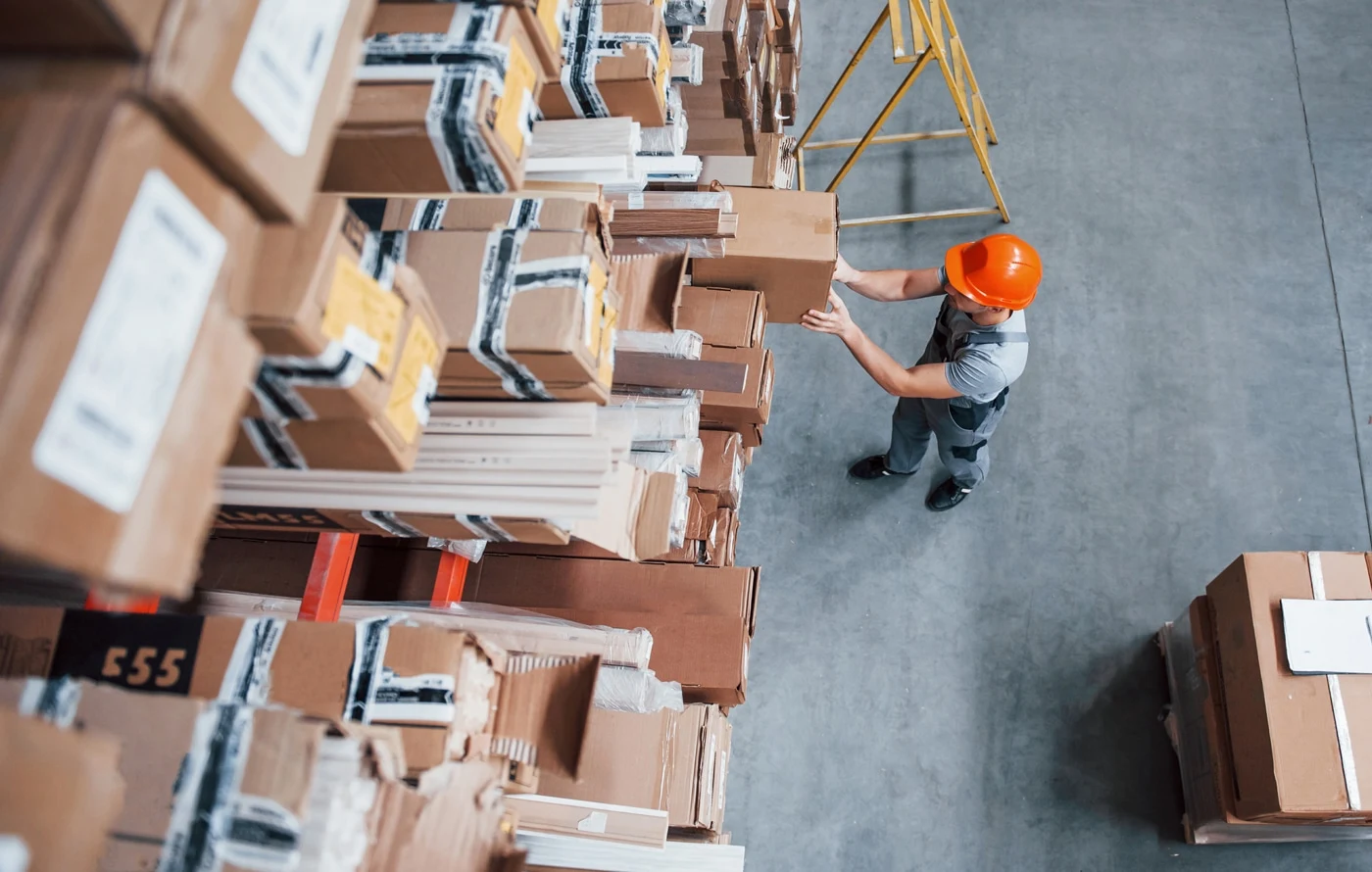 A_warehouse_worker_organizes_numerous_stacked_boxes_in_a_busy_storage_area _ISM Training_and_Recruitment