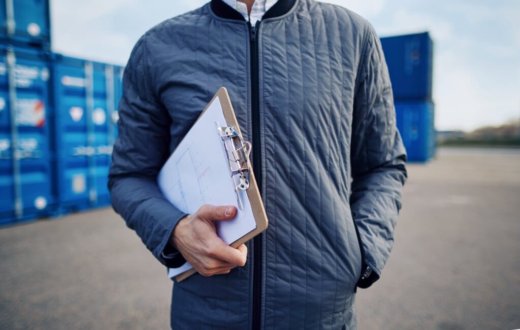 A_man_in_a_jacket_holds_a_clipboard _ISM_Training_and_Recruitment