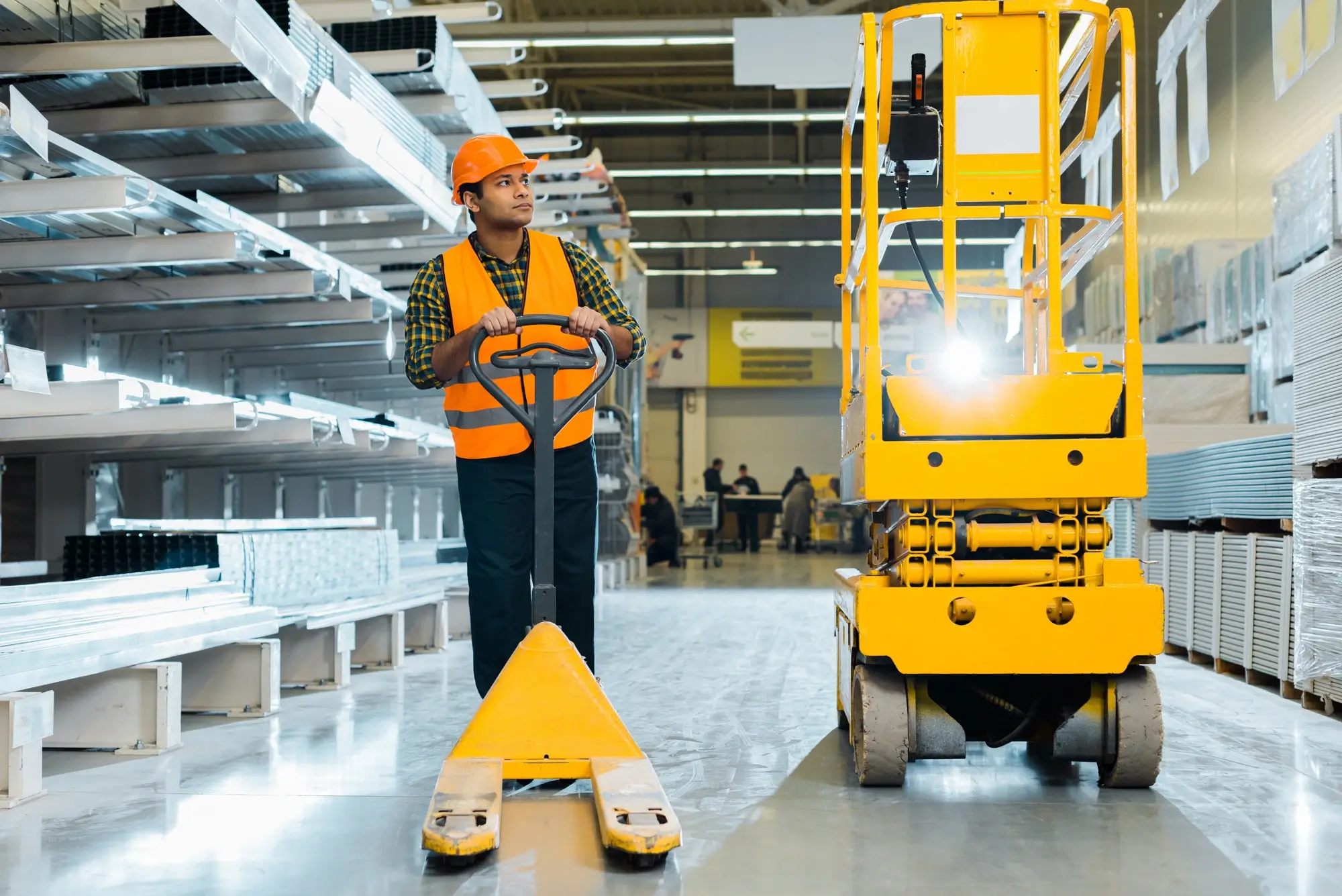 A_warehouse_worker_stands_beside_a_forklift _ISM_Training_and_Recruitment