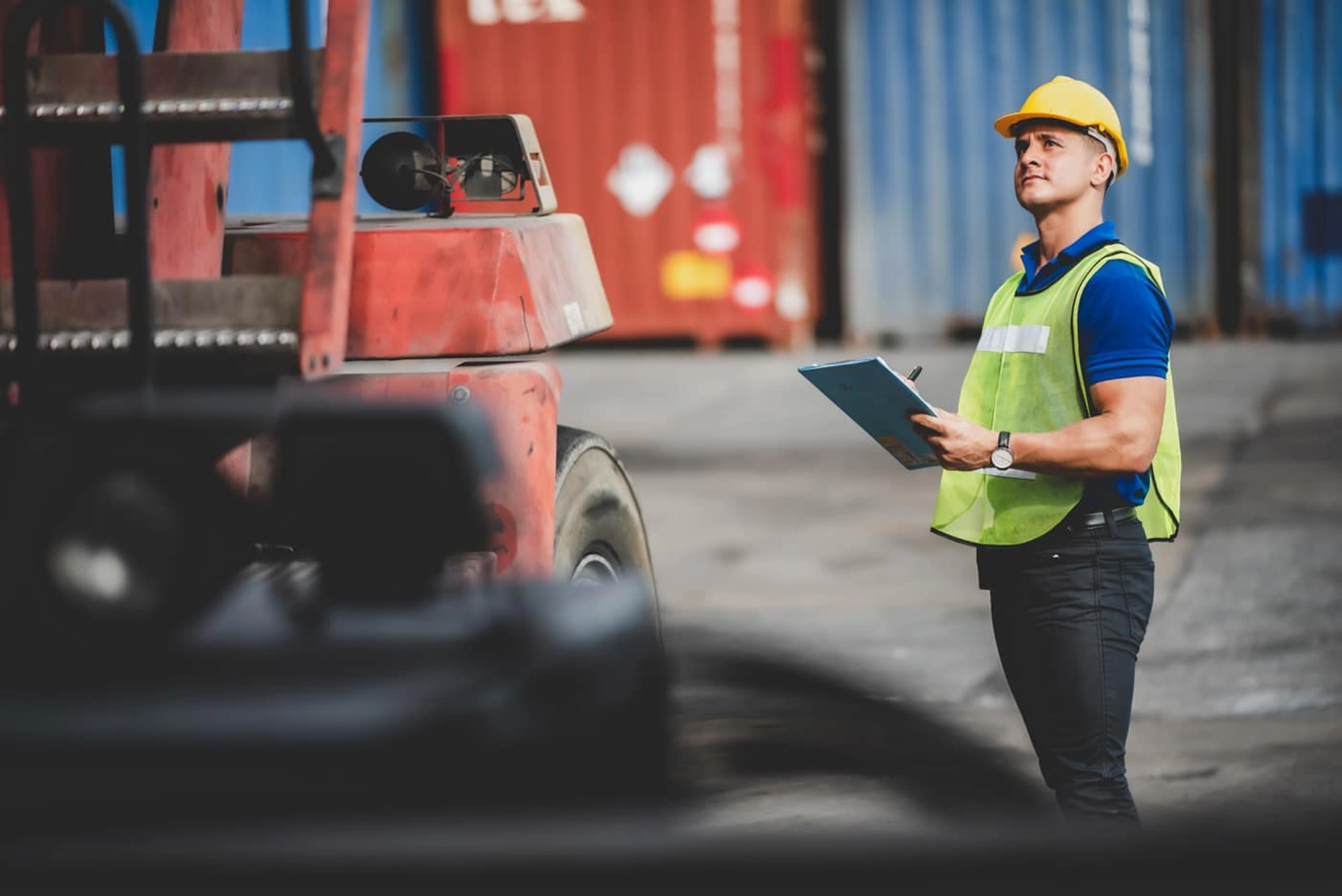 A_man_in_a_safety_vest_stands_beside_a_forklift _ISM Training_and_Recruitment