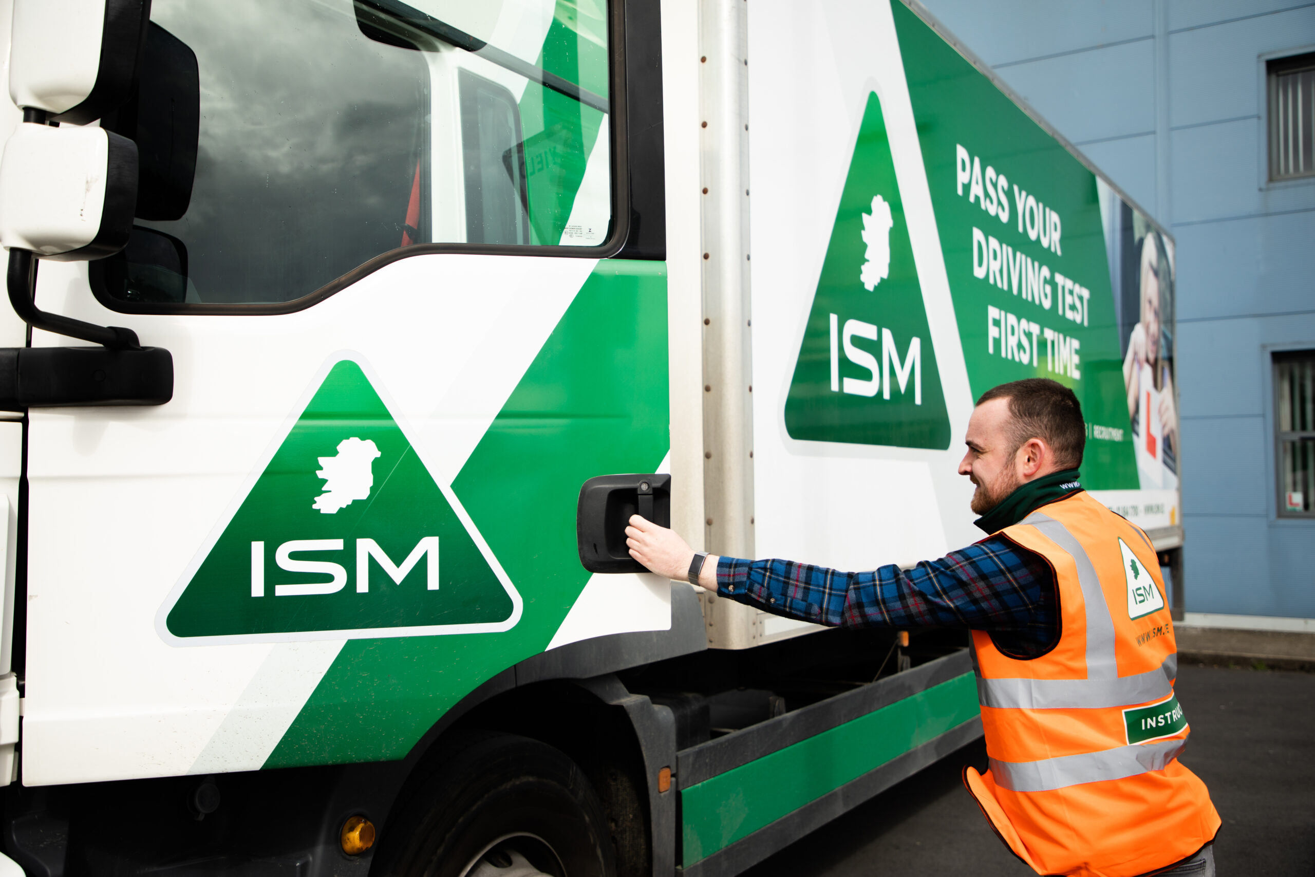 A_man_in_an_orange_vest_stands_beside_a_truck _ISM_Training_and_Recruitment