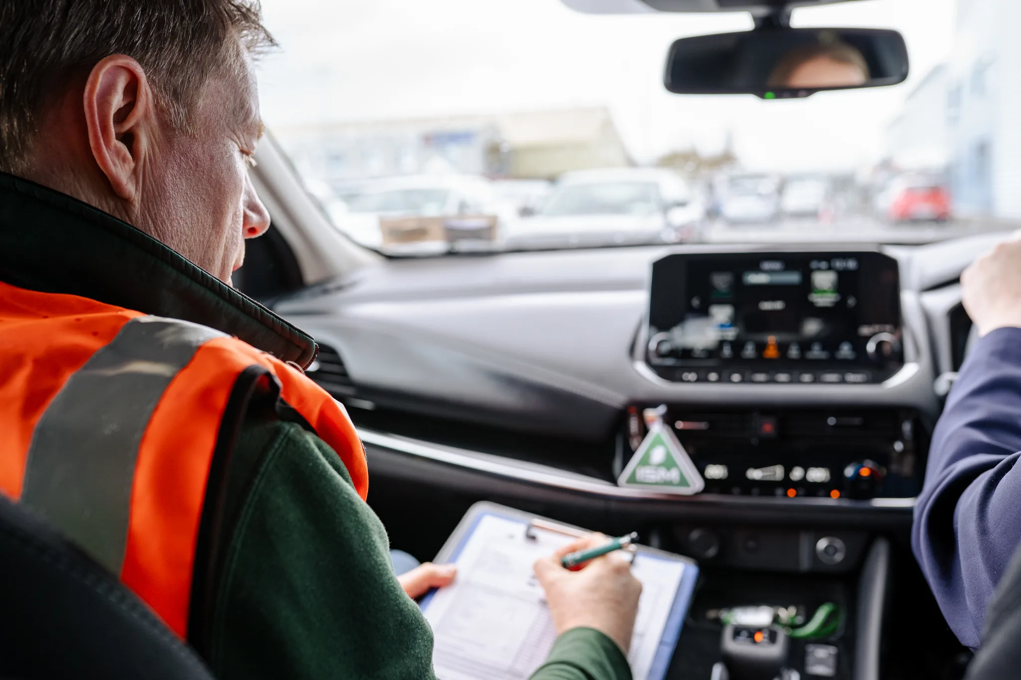 Two_men_in_safety_vests_seated_in_the_front_of_a_car _ISM Training_and_Recruitment