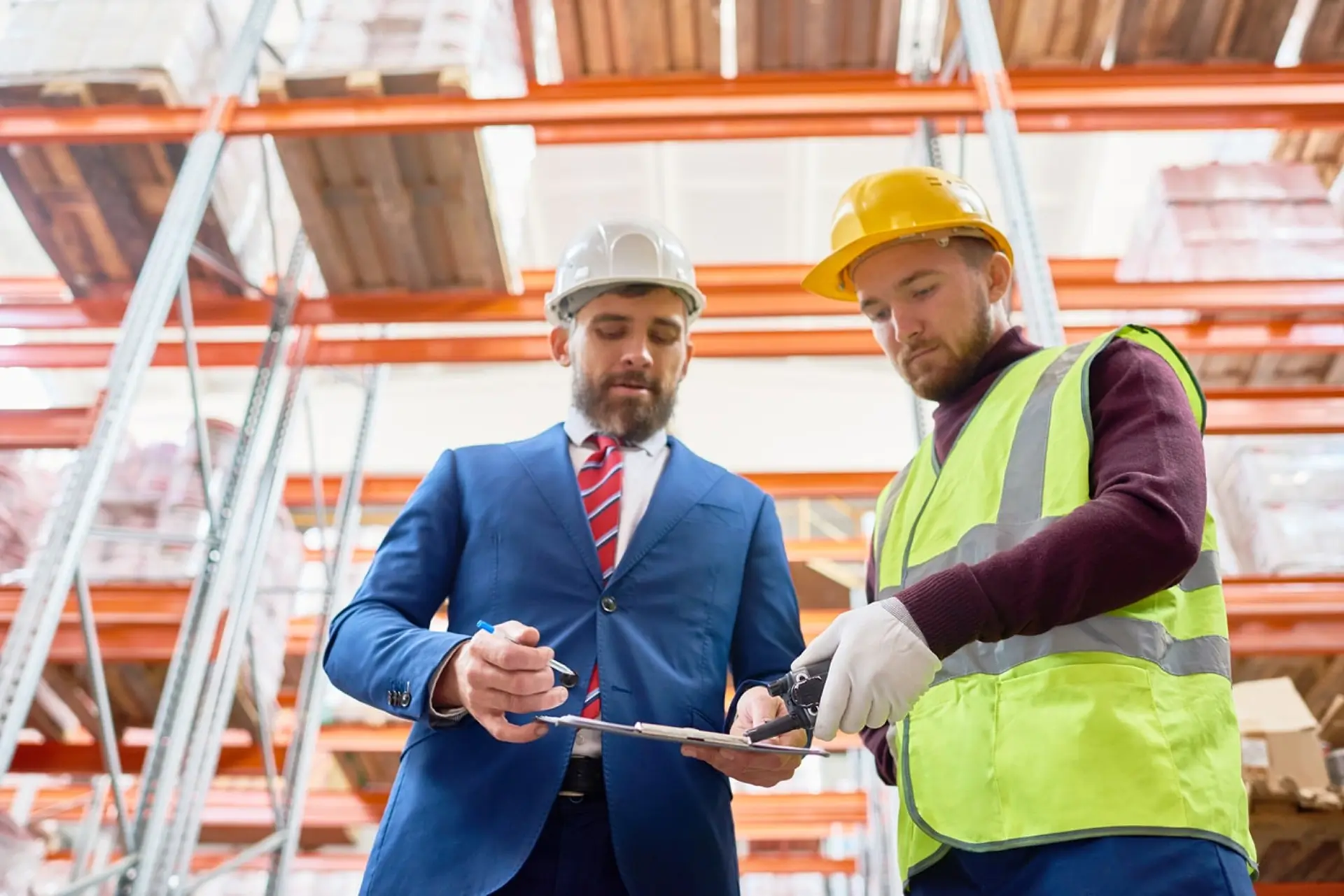 Two_men_wearing_hard_hats_stand_in_a_warehouse _ISM_Training_and_Recruitment